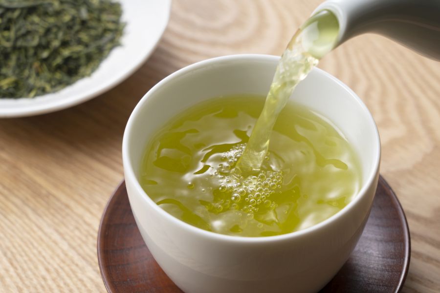 Pouring green tea into a teacup. Japanese green tea image